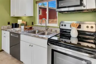 Granite and sleek stainless steel finishes dress up the open kitchen.