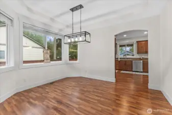 Generous-sized Formal dining room looking into kitchen. Light fixture is new. Window coverings convey