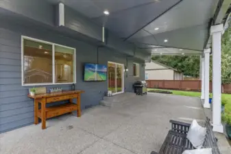Large, fully covered rear deck with a fabulous craftsman touch, has lighting, flatscreen, and 220V. The table shown here was used as a kitchen island by sellers.
