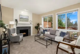 Cozy family room with gas fireplace and walls of windows that illuminate the interior with natural light.