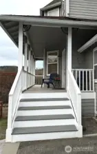 Brand new front steps leading to the front door and deck continues around the south side of the house