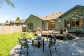 The spacious patio features a built-in gas fire pit with comfortable seating—an inviting focal point for gatherings under the stars.