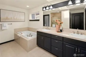The large primary bathroom features dual vanities, updated lighting, and a soaking tub ready for relaxing evenings.