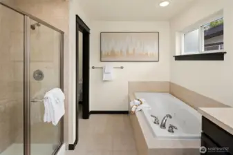 A separate glass-enclosed shower and oversized soaking tub bring spa-like comfort to the beautifully appointed ensuite.
