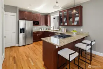 A classic U-shaped kitchen with generous granite counter space, stainless appliances, and rich cabinetry—ideal for both weeknight meals and weekend prep.