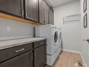 Adjacent, you'll find the strategically placed laundry room with plenty of additional storage. One of the many upgrades throughout the home.