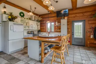 Country living Kitchen space - custom built wood table as an island that extends with spare legs to host a large group of people
