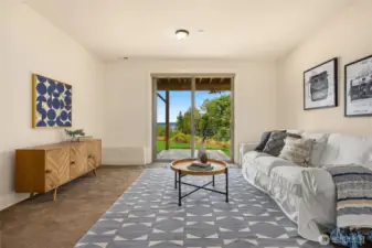 Downstairs flex space with sliding door out to a fenced yard facing the water.