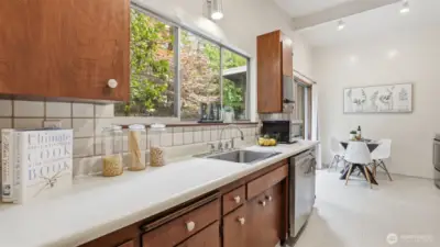 Warm sunlight and greenery create a fresh, inviting kitchen atmosphere.