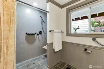Accessible shower with double heads and fold down shower seat.