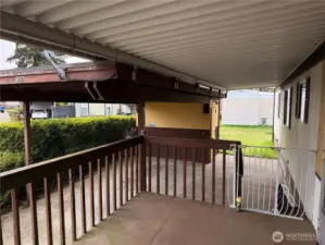 Nice covered deck entry view with carport and storage shed