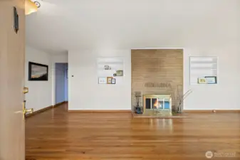 Front entry opens to a welcoming fireplace between the living (to right) and dining space (to left) with built-ins flanking either side to show off your style.