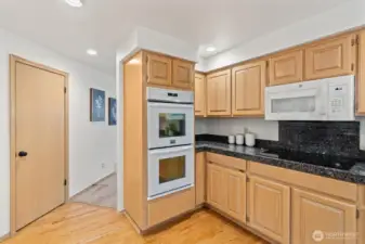 The kitchen features a double oven, electric cooktop, new microwave, granite tile, peninsula, and walk-in pantry.