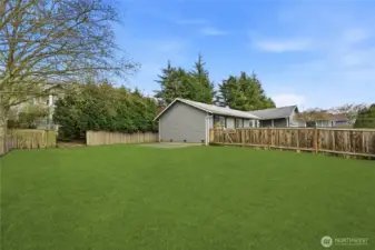 Spacious and fenced backyard offering multiple areas to enjoy the outdoors.