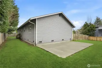 Additional patio space on the side of the home for outdoor seating or projects.