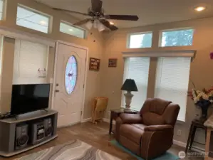 Additional view of the living room.  The home features window blinds, ceiling fan and all of the furniture pictured is included with the sale.