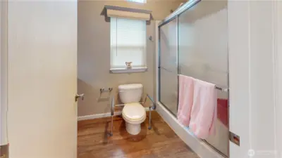 The bathroom features a large walk-in shower with seat and good size vanity with ample storage.