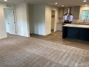 Living room looking into kitchen and primary bedroom entry.