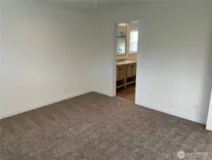 Primary bedroom looking into private bath.