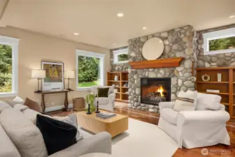 The spacious family room features  river rock clad fireplace, built-in bookshelves.