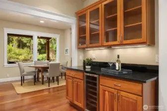 A butler's pantry with dry bar with under-counter wine  refrigerator  connects the kitchen to the dining room.