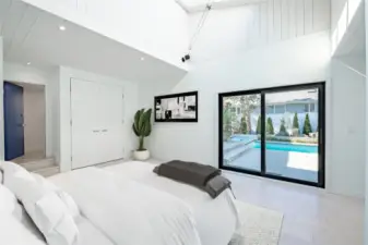 Main floor bedroom with sliders to the pool, skylights & bath
