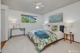 Spacious primary bedroom with new carpet and paint. The ceiling fan adds to the comfort on warm days.