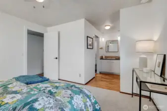 Primary bedroom with a vanity and sink separate from the main full bath. There are original oak hardwood floors under the new carpet!