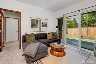 Family room with slider out to the BBQ patio & fully fenced back yard. Access to the laundry room & ¾ bath through the glass door (currently open), and the  2-car garage with extra storage racks and fridge is through the door on the left.