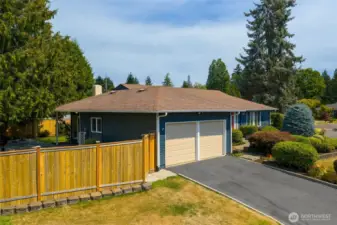 Two-car garage with extra storage and plenty of off-street parking in the driveway.