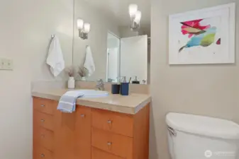 A jewel-box full bath reimagined with quartz counters, white oak cabinetry, and sculptural lighting.