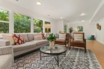 A vast and versatile haven: host movie night by the sleek and stylish gas fireplace, enjoy fitness or play at the far end, or open the slider to the garden for seamless indoor–outdoor living.