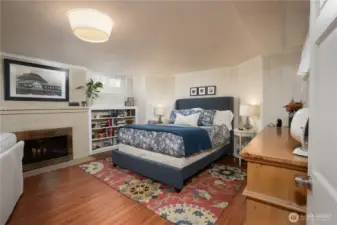 This large room, set up as a sleeping suite for the downstairs space, is huge, but the woodburning fireplace, white wood paneled walls, and pretty floors make this space super yummy and cozy.  This room is not included as one of the five bedrooms.  This home has so much space, how you use it is up to you and your wildest dreams.