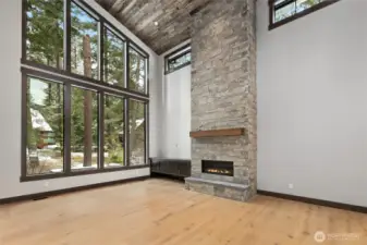 Soaring Great Room with tall windows and stone gas fireplace