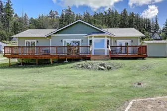 Great view looking East at your home with a large expansive deck and three sliding doors to access the home