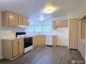 Well-designed kitchen with abundant cabinetry and pantry storage, offering a great layout for everyday cooking and entertaining. The corner sink is beneath three windows, bringing in beautiful natural light while you work.