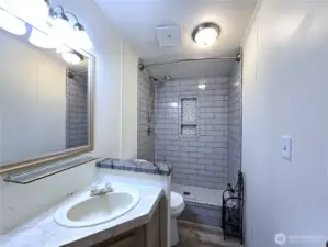 Updated hall bath featuring a beautiful tile shower and modern finishes, adding a touch of everyday luxury.