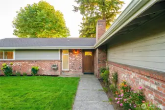 wall way to the front door, note the home is very well built has a mid-century design on the exterior - brick and hardy board plank and new roof 2021