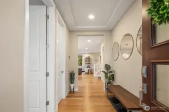 Covered porch welcomes all into home's foyer- note main floor guest suite just off to left