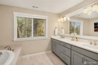 Five piece primary bath features Quartz countertops, undermount sinks, tiled floor, soaking tub and oversized seamless glass shower