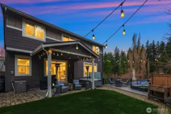 Twilight in the backyard offers a serene, private setting. Note the covered patio plumbed for your gas grill.