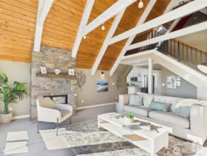 The cozy family room connects to the upstairs loft and third bedroom via a custom iron railing, blending comfort with unique architectural detail.