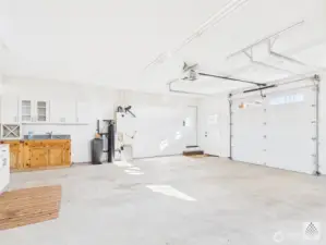 The spacious two-car garage also features a second dedicated workspace with upper and lower cabinet and a fully function sink - perfect for projects, hobbies and extra storage.
