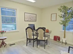 Office overlooks adjacent lush riverfront park and back yard through the other window