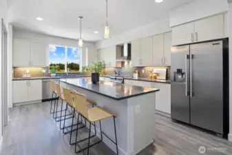 Chef's dream kitchen boasts a gas cooktop, spacious center island with seating for 4, a walk-in pantry, sleek quartz countertops and under cabinet task lighting.