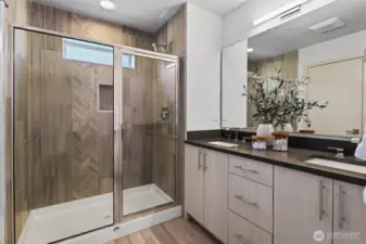 Primary bath boasts oversized shower plus dual vanities with quartz counters and undermount sinks