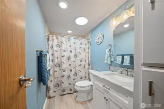 The freshly updated hall bathroom has new LVP flooring and vanity with granite counter