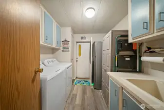 The laundry room is complete with deep sink and room for more storage