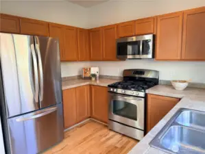 The bright kitchen features stainless steel appliances including a new refrigerator