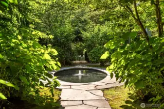 The elliptical pond welcomes guests and draws them through the garden layered with lavender, roses, hydrangea and espaliered apple trees.